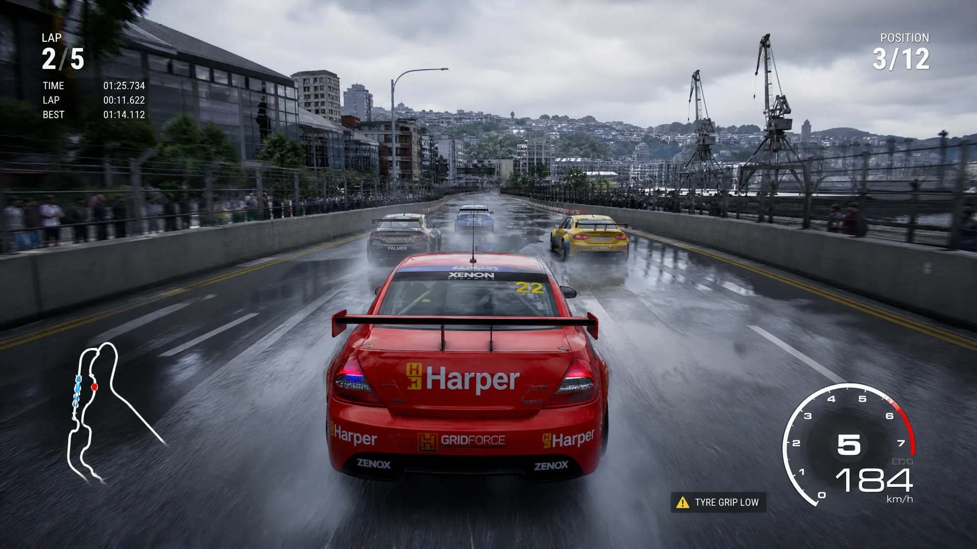 Touring cars racing side by side on a wet New Zealand coastal circuit.